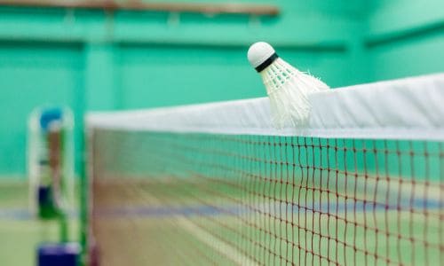 Shuttlecock gets stuck on the top of the net, an example of let in badminton